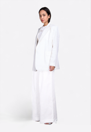 Side view of model wearing white linen blazer, East Vibe